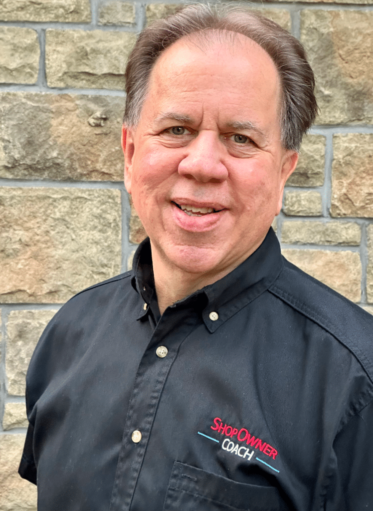 Image of Vic Tarasik, Shop Owner Coach, standing confidently in front of a brick wall wearing a black shirt.